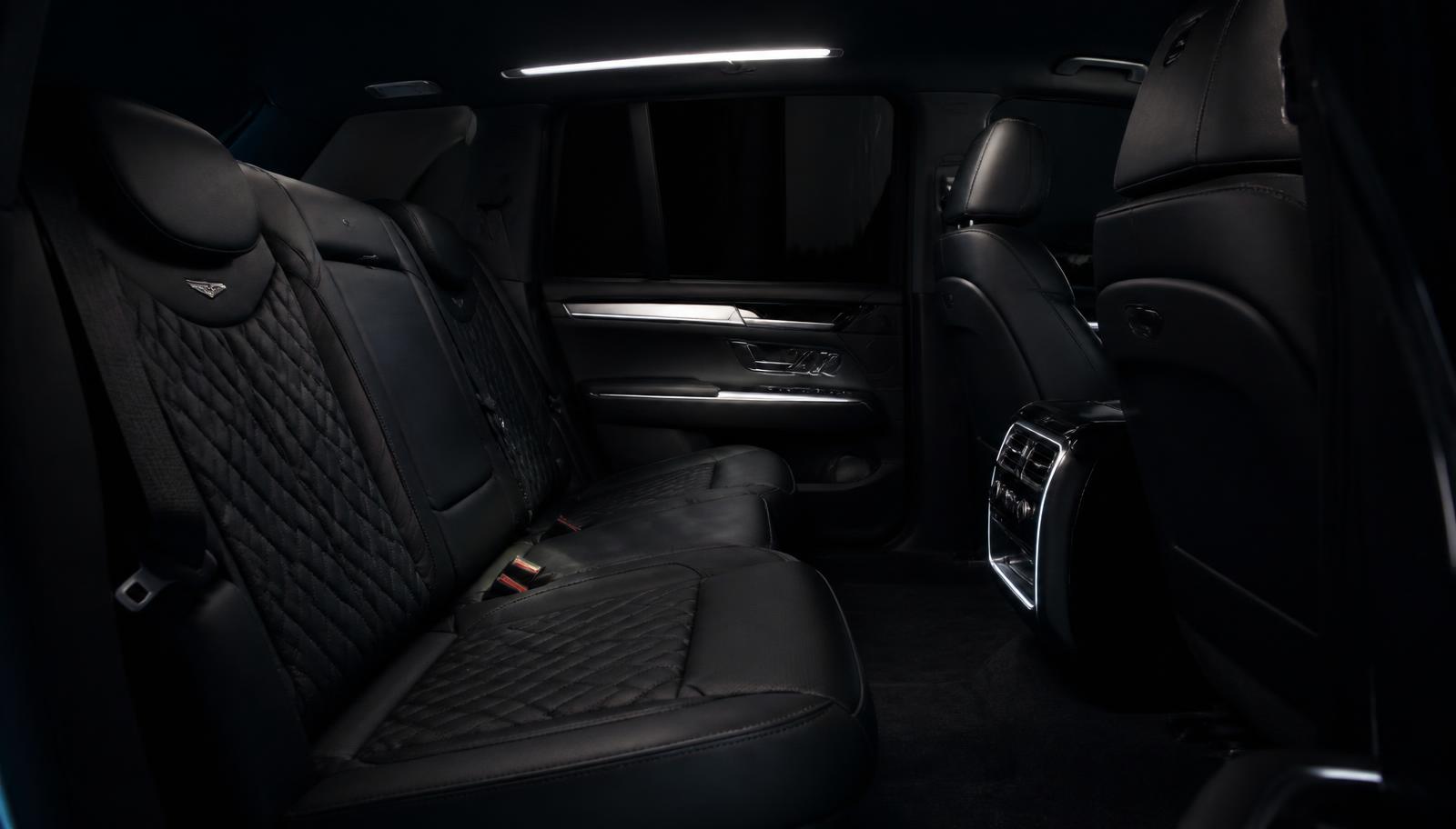 Interior of a luxury SUV rear cabin with black leather seating